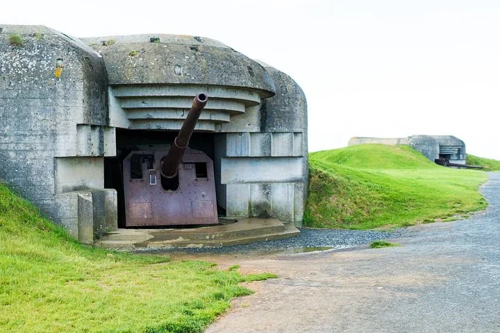 A concrete German gun casemate with a heavy gun still in place and grass on its roof